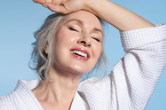 A smiling woman showing off glowing and healthy skin.