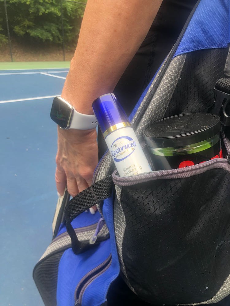 Close up of an open backpack with a bottle of Restoracell (Vitali) copper peptide serum.