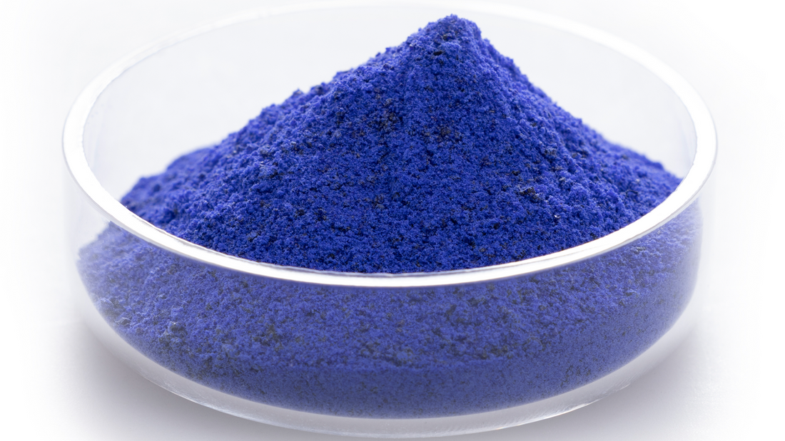 Blue sand-like substance in a small petri dish.